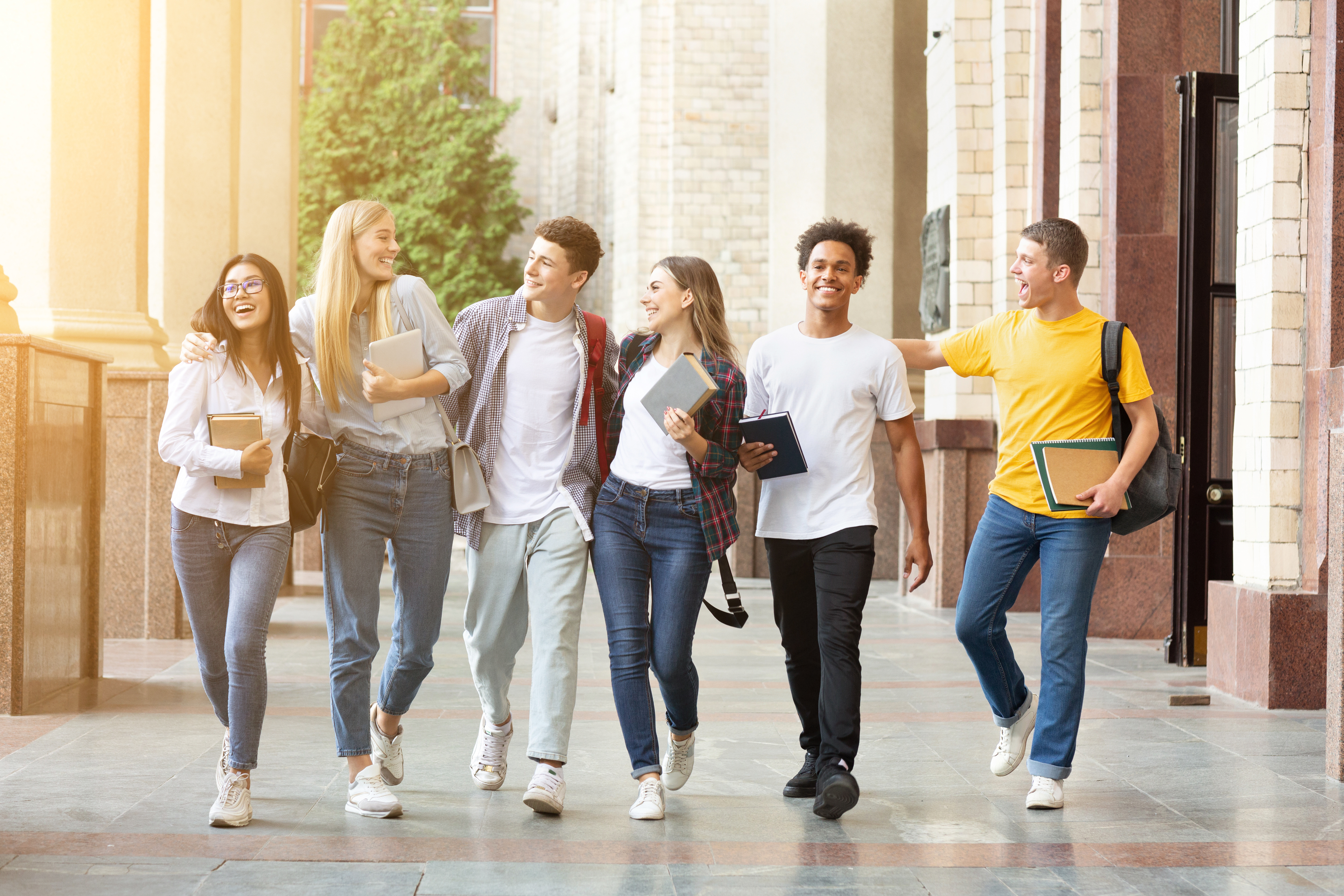 Diverse students walking together in campus, having break after classes